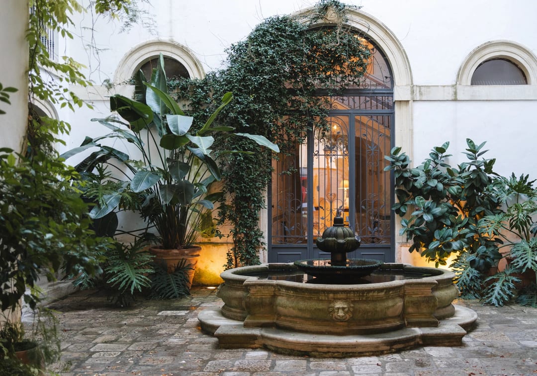 Ivy-covered courtyard with a stone fountain at dusk